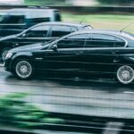 Blurred image of two cars racing on a wet highway, highlighting speed and motion.